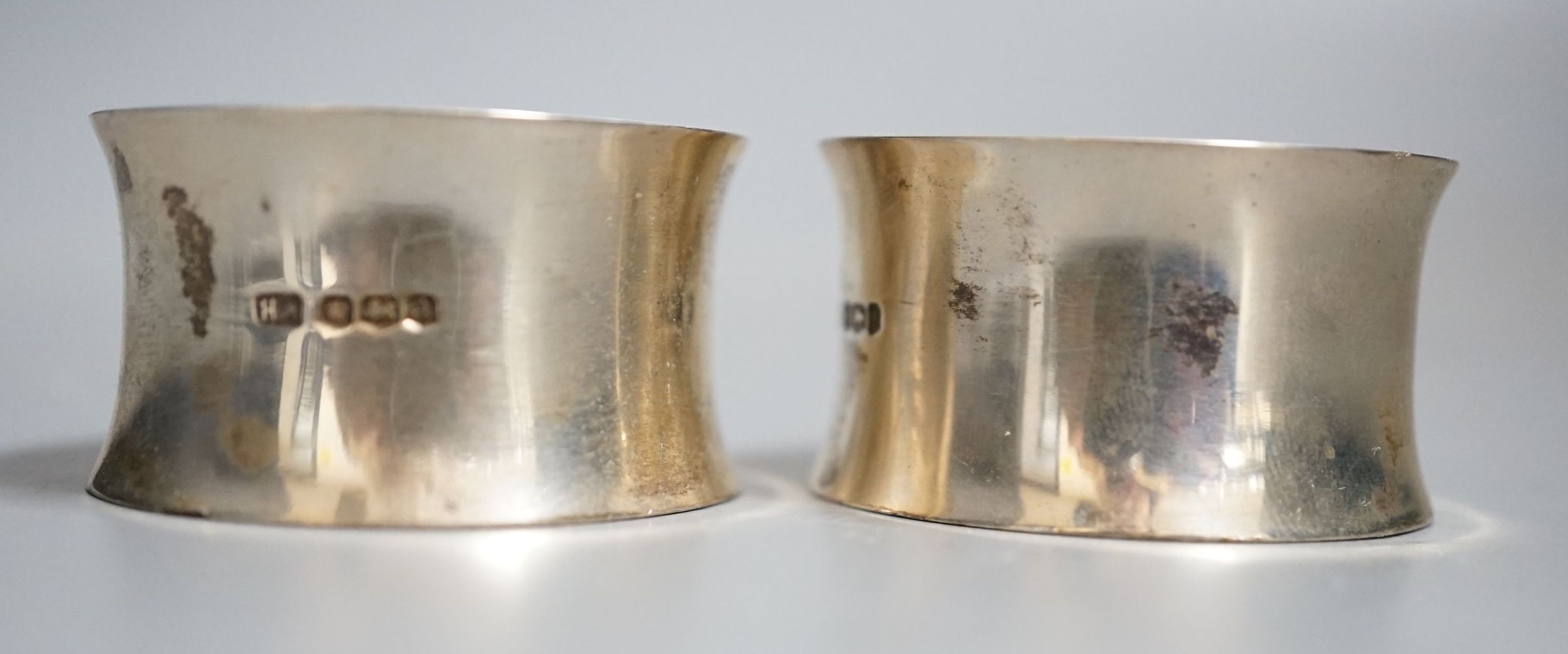 A pair of George V silver napkin rings, Atkin Brothers, Sheffield, 1918, engraved with the letter L, 85 grams.